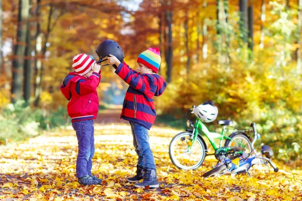 Két kis gyerek kerékpárok őszi erdőben fiúk — Stock Fotó