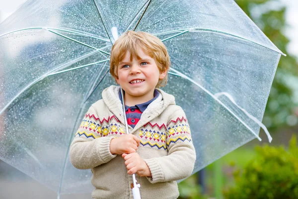 Liten blond liten pojke promenader med stora paraply utomhus — Stockfoto