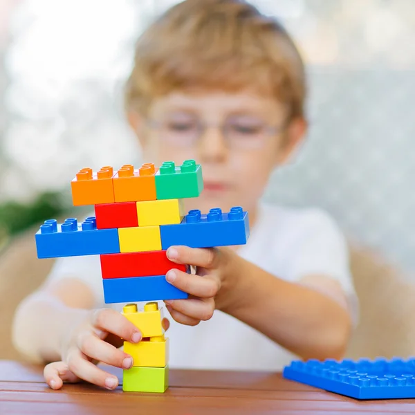 Liten unge pojke leker med plast block — Stockfoto