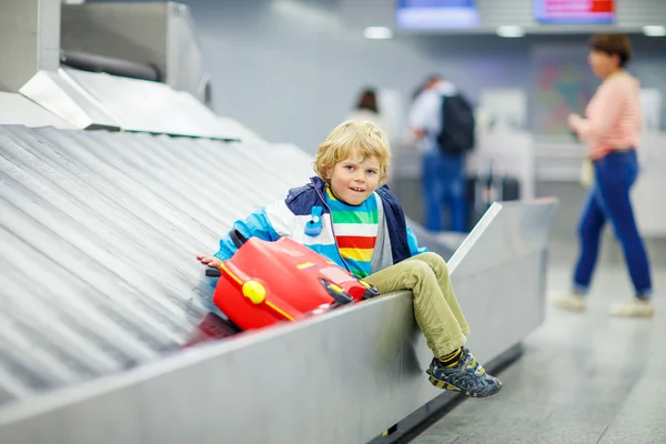Маленький втомлений хлопчик в аеропорту, подорожує — стокове фото
