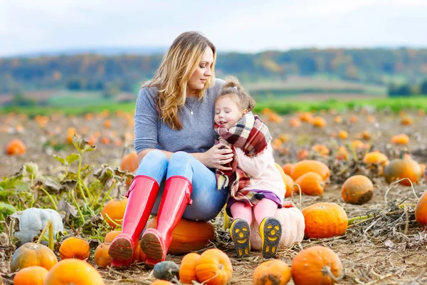 Little kid girl and mother having fun on pumkin field — Stock Photo, Image