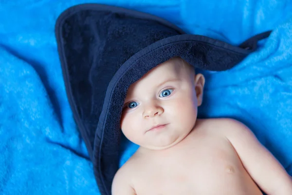 Menino menino pequeno contra a toalha de banho azul — Fotografia de Stock