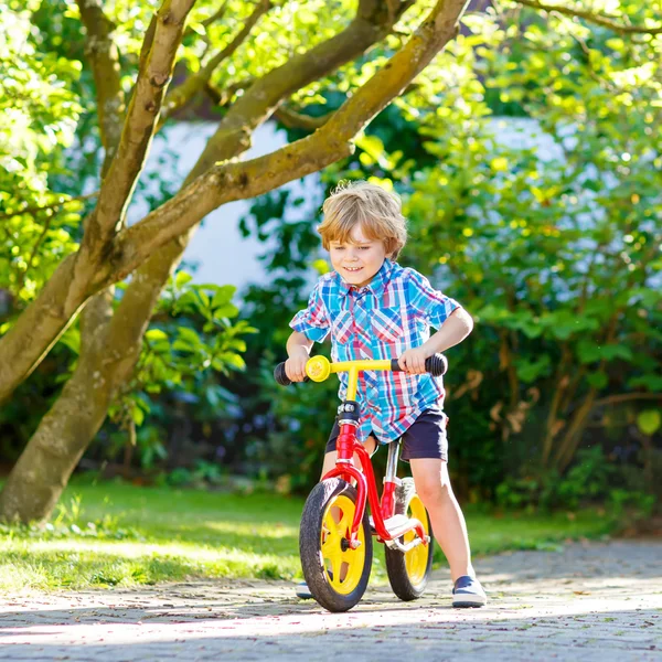 Junge fährt Dreirad oder Fahrrad im Garten — Stockfoto