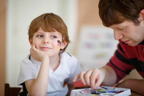 Bandera de pintura del padre en la cara del niño pequeño para el fútbol o el fútbol — Foto de Stock