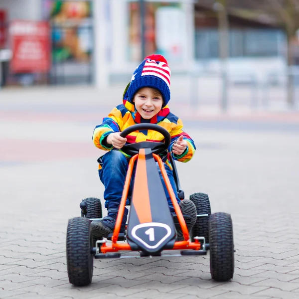 Niño pequeño que se divierte en coche de carreras de juguete al aire libre — Foto de Stock
