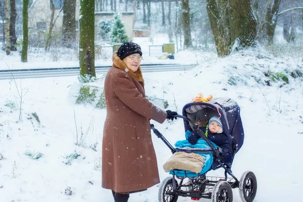 Büyükanne ile erkek bebek kış aylarında yürüyüş — Stok fotoğraf