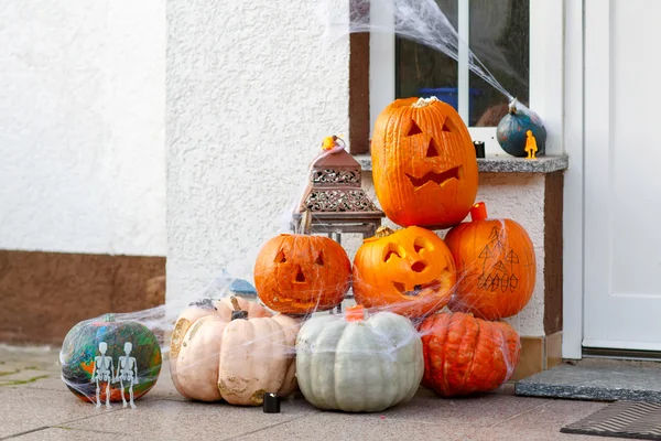 Drzwi do domu urządzone na Halloween z przerażające Jack-o-Lantern pompy — Zdjęcie stockowe