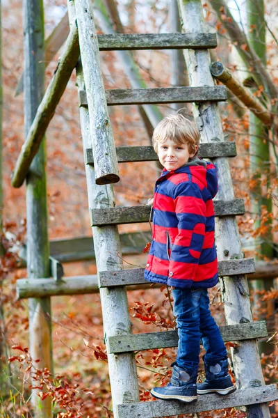 Schattig kleine jongen op herfst bladeren achtergrond in park. — Stockfoto