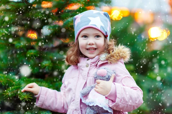 Beautiful smiling little girl holding christmas tree — Stock Photo, Image