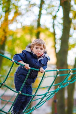 Açık sahada sonbahar gününde tırmanma çocuk evlat