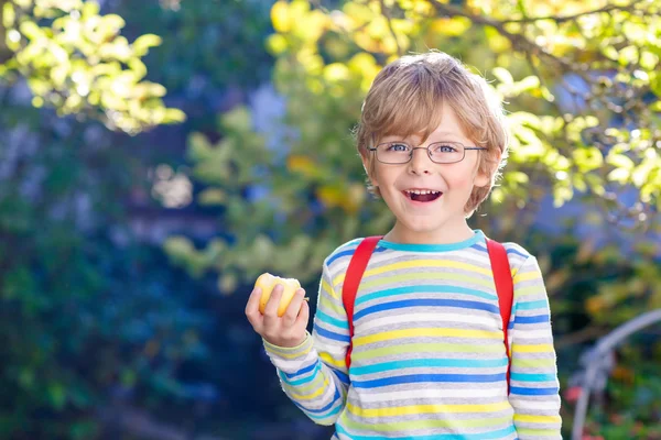 Маленький мальчик с яблоком по дороге в школу — стоковое фото