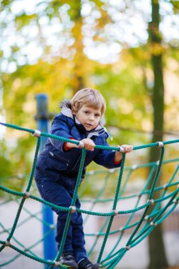 Açık sahada sonbahar gününde tırmanma çocuk evlat