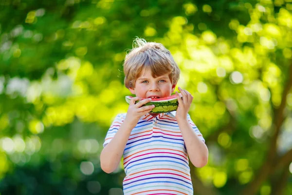Chlapeček předškolní dítě jíst meloun v létě — Stock fotografie