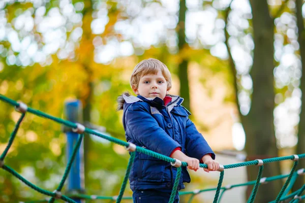 秋の日の屋外の遊び場に登って少年を子供します。 — ストック写真