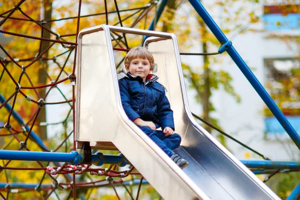 Kid jongen klimmen op buitenspeeltuin op herfstdag — Stockfoto