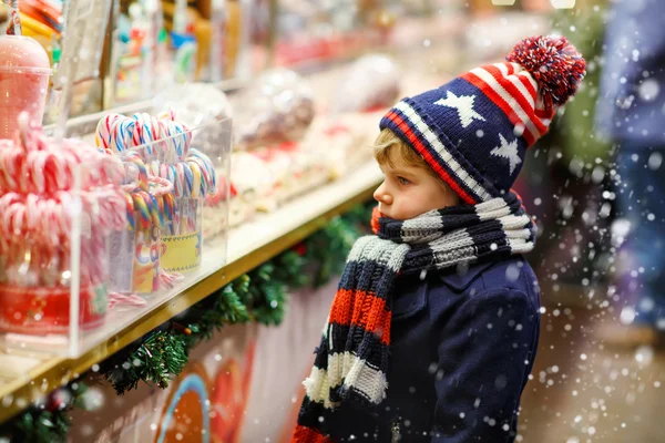 Mały chłopiec dziecko z trzciny cukrowej candy stanąć na Jarmark Bożonarodzeniowy — Zdjęcie stockowe