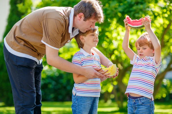 Two little preschool kid boys and father eating watermelon — Stock Photo, Image