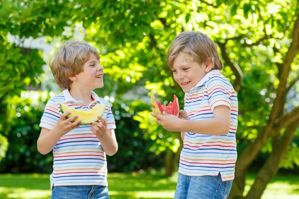 Dva malí chlapci předškolní dítě jíst meloun v létě — Stock fotografie