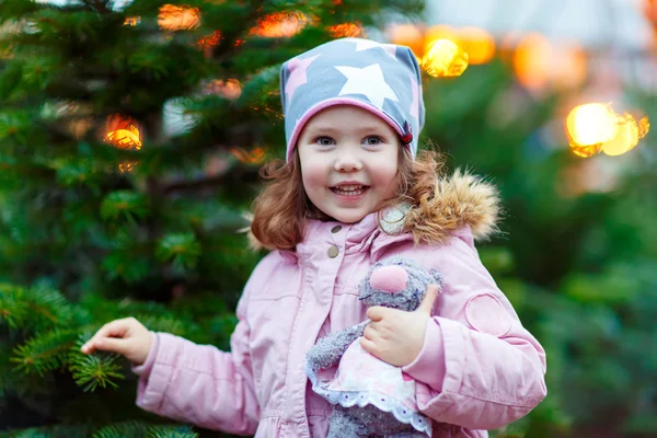 Bela sorrindo menina segurando árvore de Natal — Fotografia de Stock