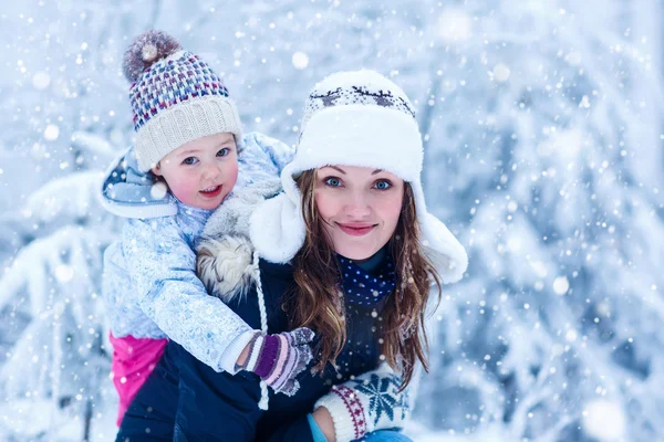 Portrait of a little girl and her mother in winter hat in snow f — Stock Photo, Image
