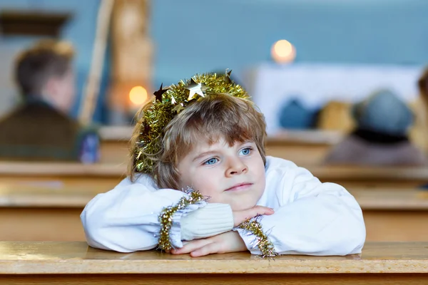 Niño pequeño jugando un ángel de la historia de Navidad en la iglesia — Foto de Stock