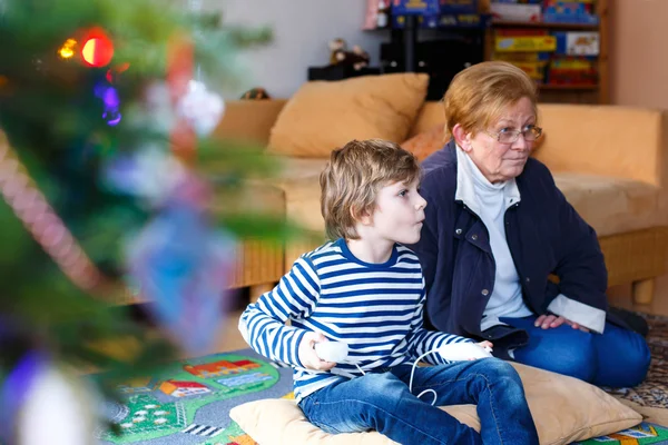 Menino e avó jogando console de videogame — Fotografia de Stock