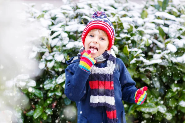 Happy child having fun with snow in winter — Stock Photo, Image