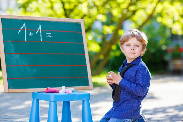 Lille dreng på tavle øve matematik - Stock-foto