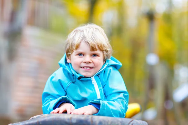 Malý chlapec dítě baví na podzimní dětské hřiště — Stock fotografie