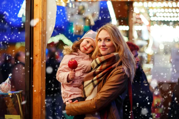 Mother and little daughter eating crystalized apple on Christmas — Stock Photo, Image