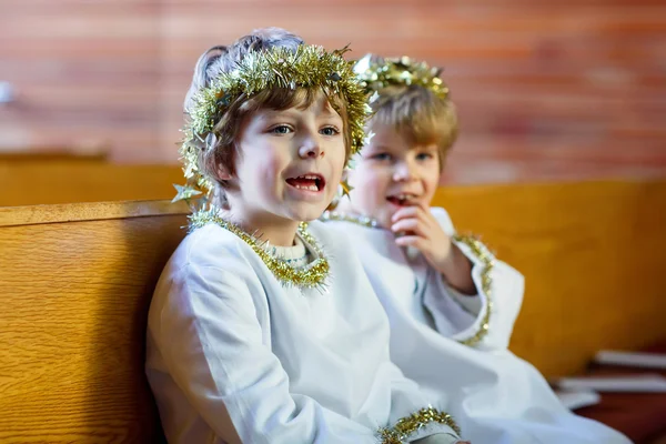 Dois garotinhos jogando um anjo da história de Natal na igreja — Fotografia de Stock