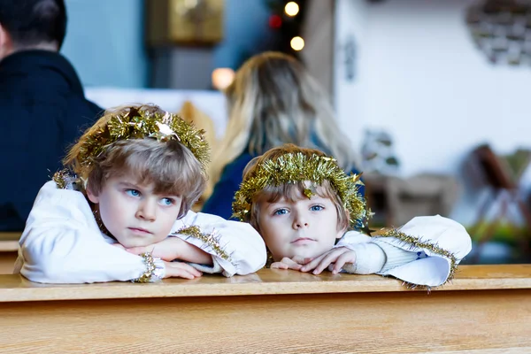 Zwei kleine Jungen spielen Weihnachtsengel in der Kirche — Stockfoto