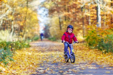 Küçük çocuk çocuk sonbahar ormandaki bisiklet ile