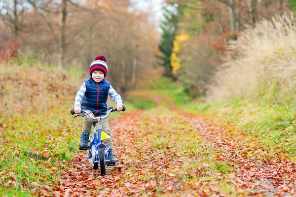 Little kid boy with bicycle in autumn forest — Stock Photo, Image