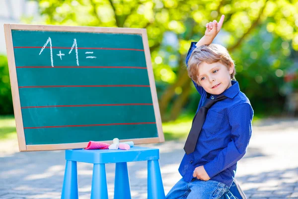 Petit garçon au tableau noir pratiquant les mathématiques — Photo