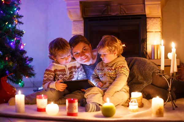 若い母親と C に暖炉のそばに座って彼の小さな子供たち — ストック写真