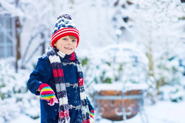 Lykkelig guttunge som morer seg med snø om vinteren – stockfoto