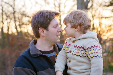 Baba ve küçük park veya orman, açık havada.