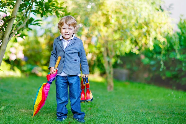 Weinig schattig peuter jongen met kleurrijke paraplu en laarzen, outdoo — Stockfoto