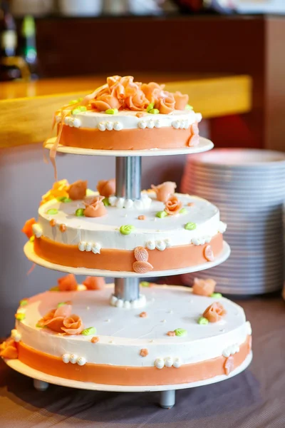 Delicious wedding cake with flowers, in white and orange — Stock Photo, Image