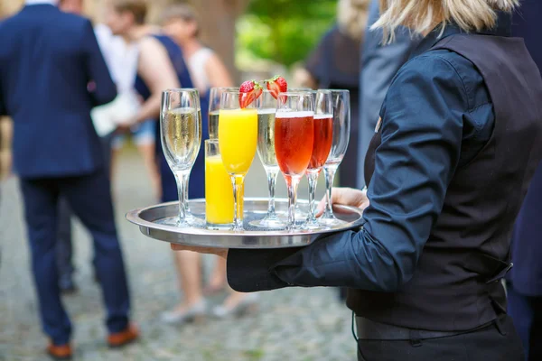 Garçonete com uma bandeja de copos de bebidas diferentes no casamento — Fotografia de Stock