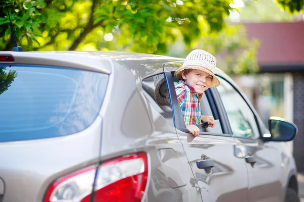 Kleiner Junge sitzt kurz vor der Abreise in den Urlaub im Auto — Stockfoto