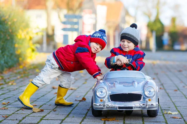 两个小孩子男孩在玩玩具车，在户外 — 图库照片