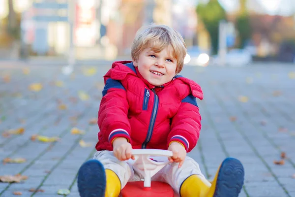 Divertido niño pequeño niño conducir juguete coche al aire libre — Foto de Stock