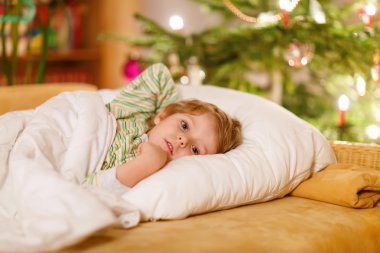 Noel ağacının altında uyuyan küçük şirin çocuk çocuk