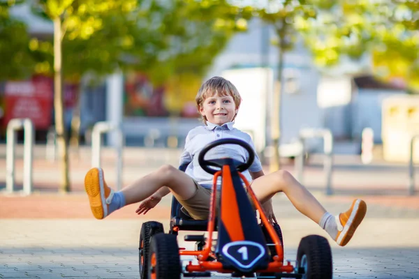 Little kid boy driving pedal race car in summer — Stock Photo, Image