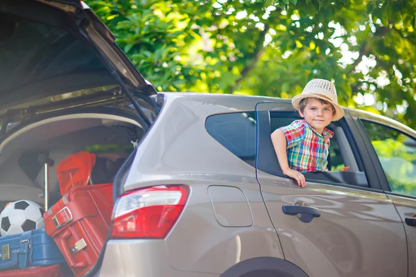 Kleine jongen jongen in auto zit net voor vertrek voor vakantie — Stockfoto