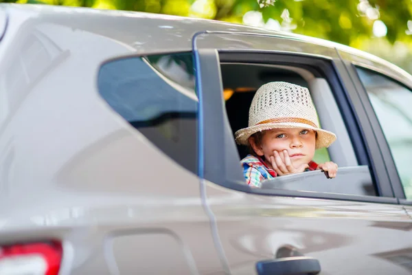 Sad tired kid boy sitting in car  during traffic jam — Stock Photo, Image