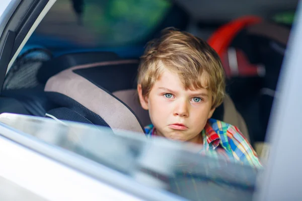 Triste menino cansado sentado no carro durante o engarrafamento — Fotografia de Stock