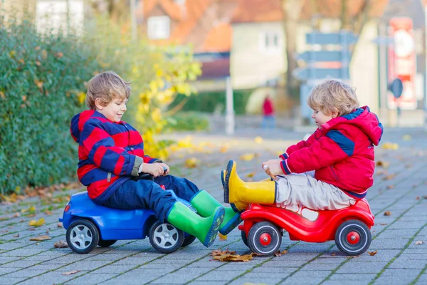 Dwa małe dzieci chłopców bawiących się z autka, na zewnątrz — Zdjęcie stockowe